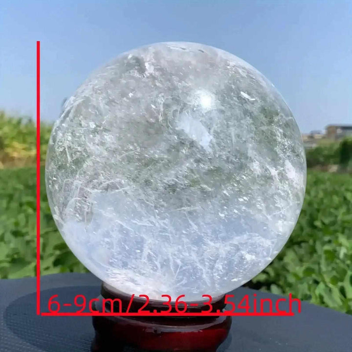 Polished Clear Quartz crystal sphere with internal veils and cloudy textures, perfect for Crown Chakra meditation focus.