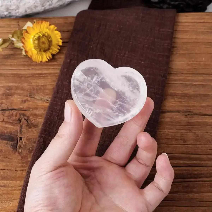 Polished clear quartz heart bowl, a 50-60mm crystal dish for Crown Chakra healing, intentions, and holding small stones.