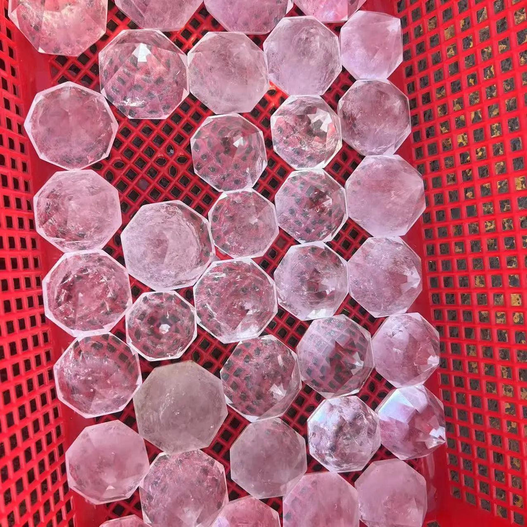 Pink clear quartz crystal hexagonal pyramids for reiki healing, displayed in a red basket.