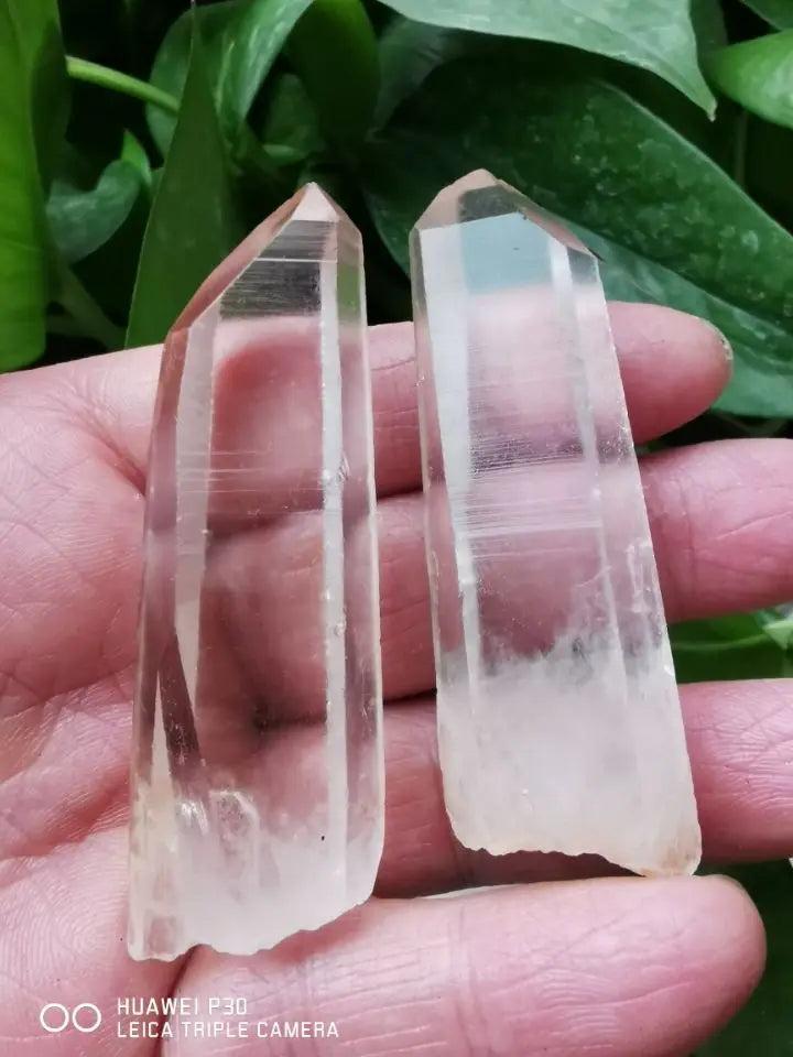 Two natural Clear Quartz Lemurian Seed Crystal wands, displaying characteristic horizontal striations and high-vibration energy.