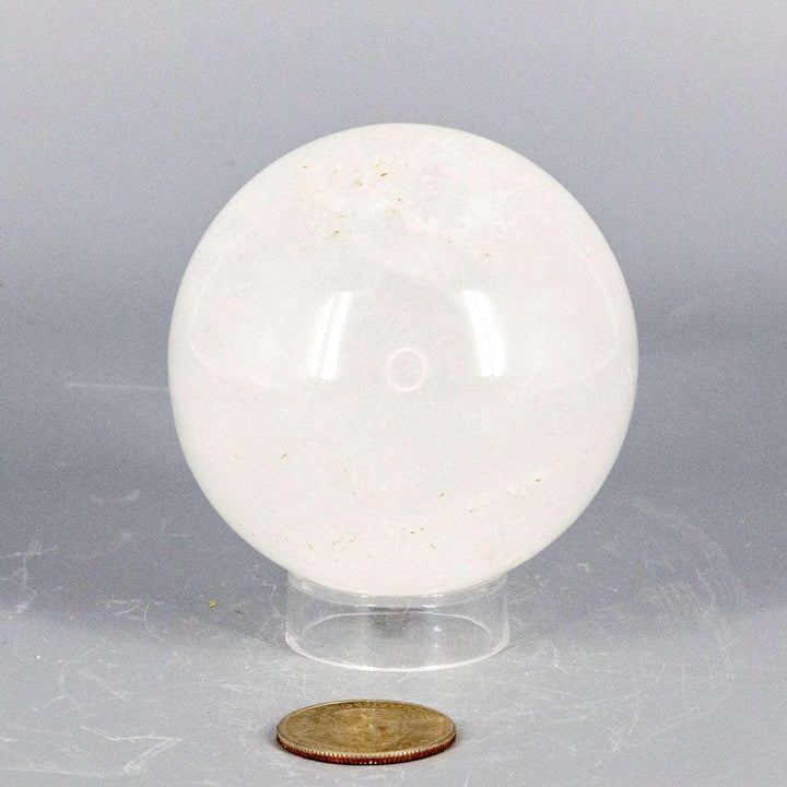 Clear Quartz Sphere 67mm, radiating energy with natural inclusions and veils, perfect for meditation or display.