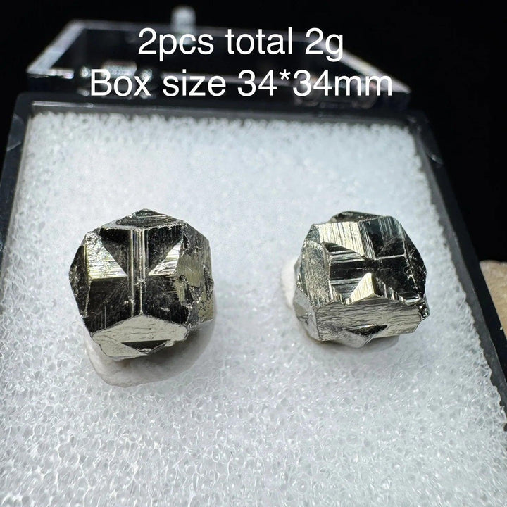 Two raw Colombia Cross Pyrite crystals with metallic gold luster in a 34mm display box, perfect for healing and home decor.