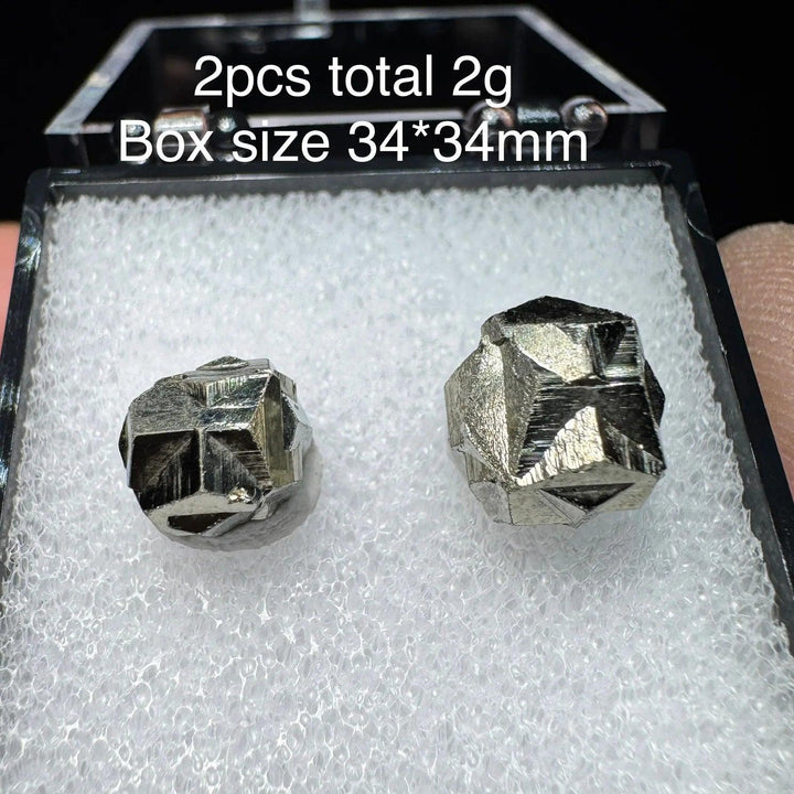 Two natural Colombia cross pyrite crystals with metallic luster in a 34x34mm display box, perfect for healing and home decor.
