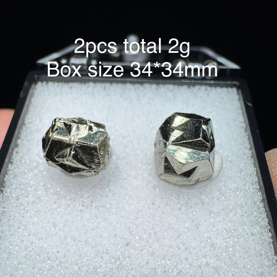 Two raw Colombia Cross Pyrite crystals with metallic gold luster in a 34x34mm display box for healing and home decor.