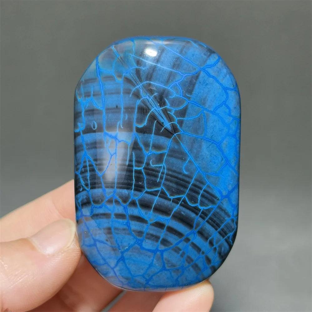 Polished blue agate palm stone with a striking dragon scale pattern, perfect for healing, meditation, and home decor.