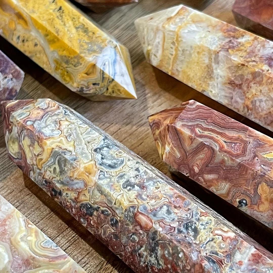 Crazy Lace Agate crystal towers with swirling bands of cream, rust, gold, and pink, in various sizes.