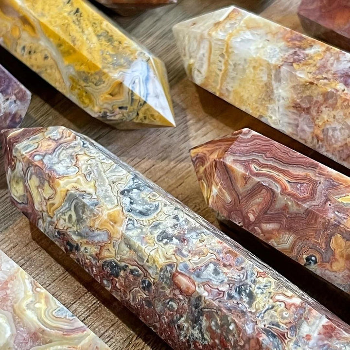 Crazy Lace Agate crystal towers with swirling bands of cream, rust, gold, and pink, in various sizes.