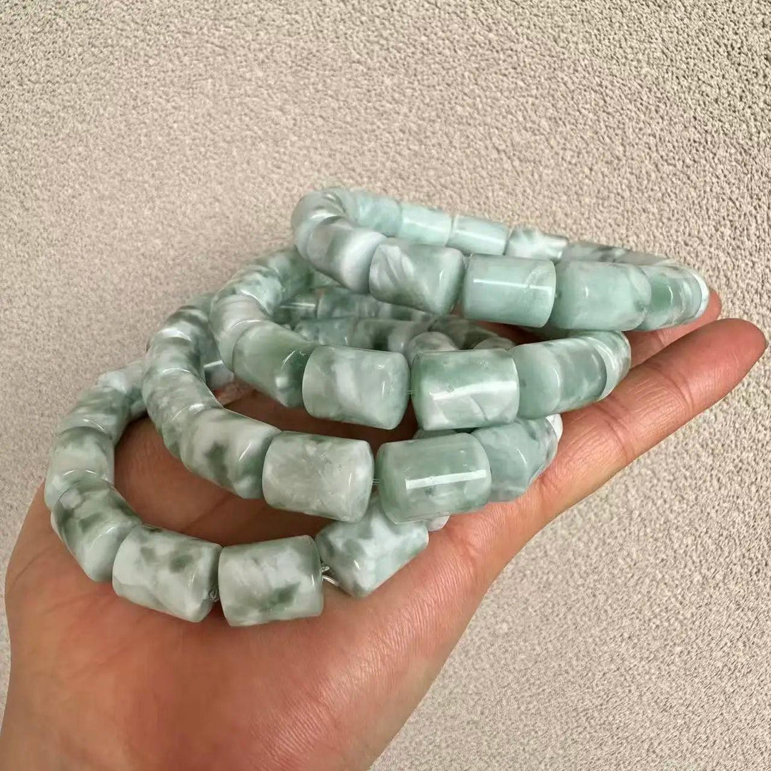 Hand holding three light green and white barrel-cut natural stone Crystal Big Beads Bracelets.