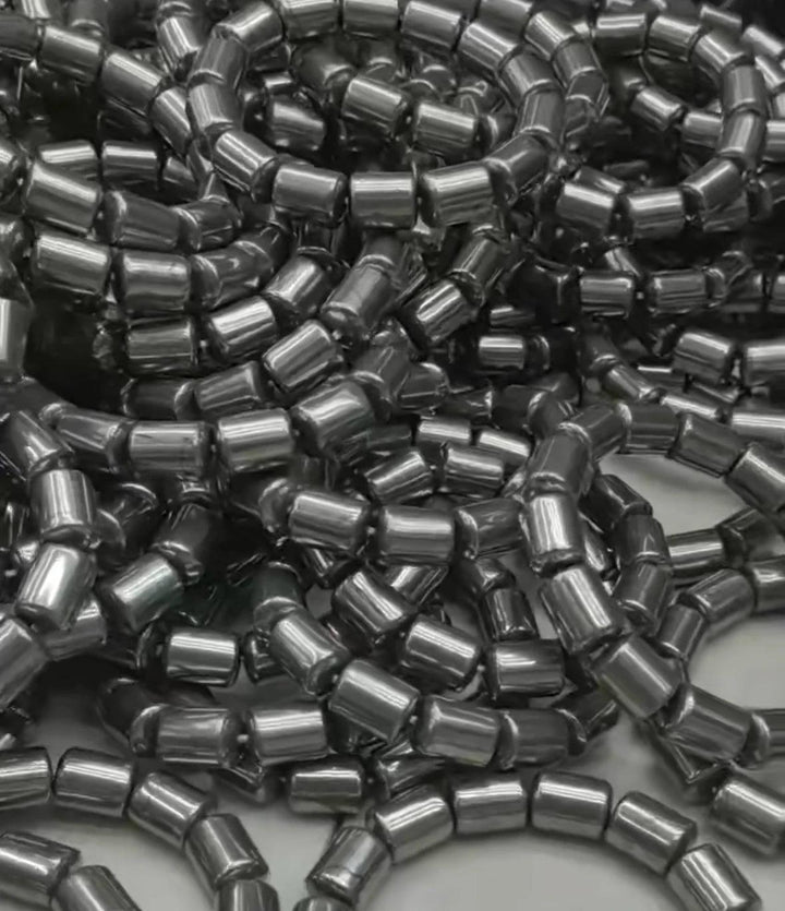 Pile of shiny, dark gray barrel-cut beads for a Crystal Big Beads Bracelet, ready for daily intention work.