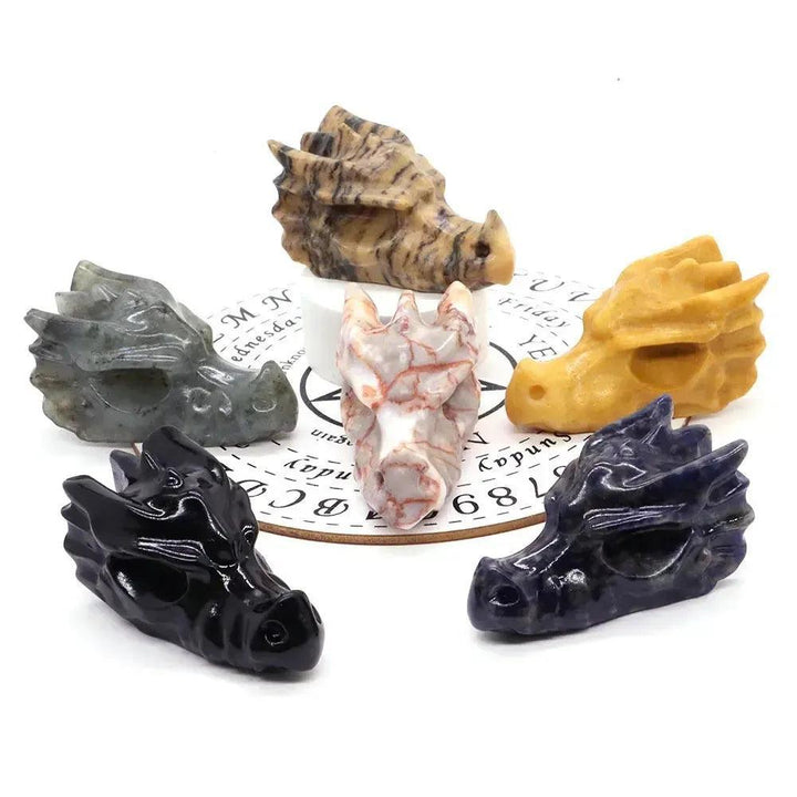 Assorted crystal dragon heads: black obsidian, gray labradorite, yellow calcite, red veined jasper, and blue sodalite.