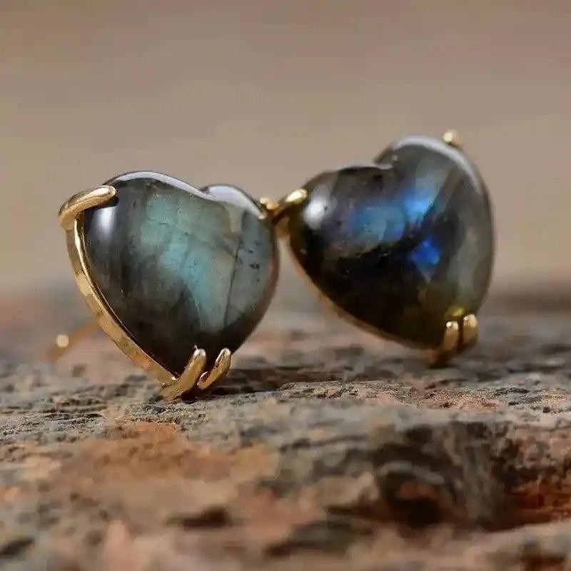 Heart-shaped labradorite gemstone stud earrings, showcasing iridescent blue-green flashes in polished gold settings.