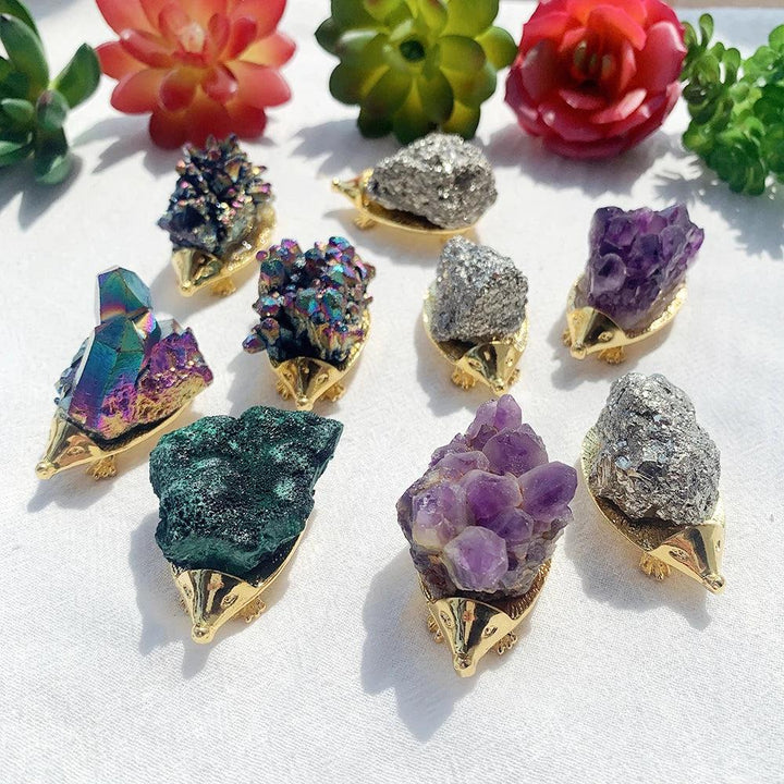 Assorted Crystal Hedgehog Figurines: vibrant amethyst, iridescent rainbow cluster, and sparkling chalcopyrite for healing and growth.