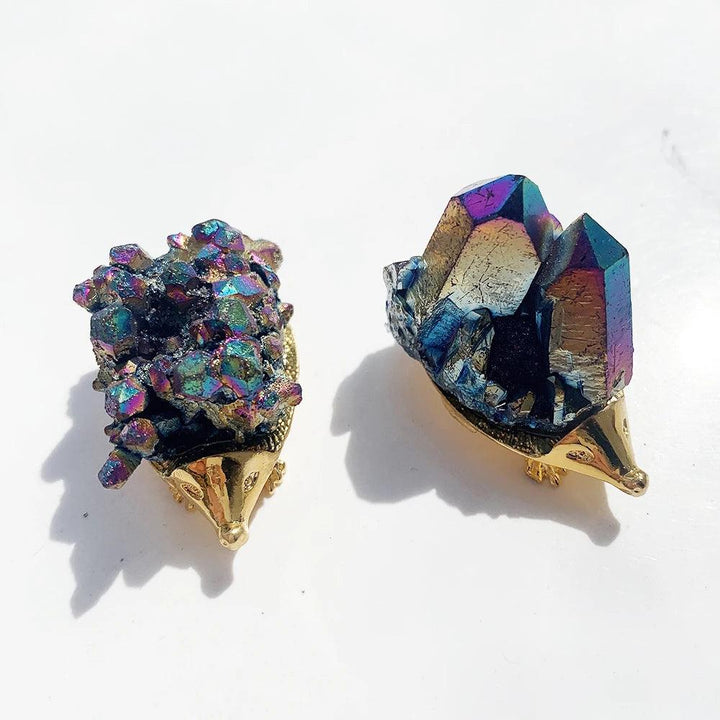 Two iridescent Rainbow Cluster Crystal Hedgehog Figurines with golden bases, radiating magical energy.