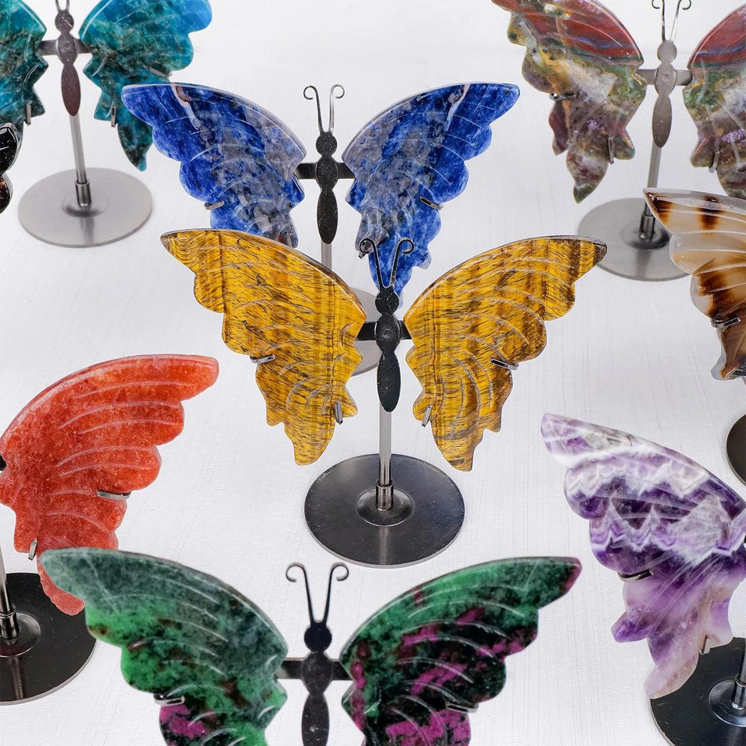 Polished crystal butterfly wings in various stones like yellow Tiger Eye, blue Sodalite, red Agate, and green Epidote.