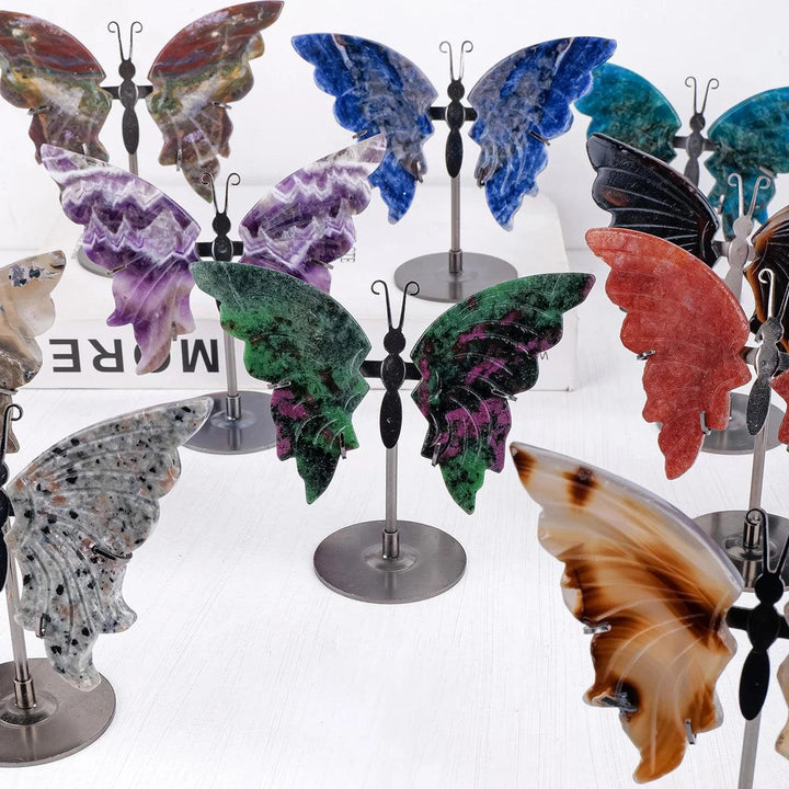 Polished crystal butterfly wings in various natural stones like Amethyst, Ocean Jasper, and Tiger Eye on stands.