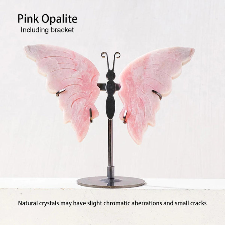 Polished pink Opalite crystal butterfly wings on a black metal stand, symbolizing growth and new beginnings.