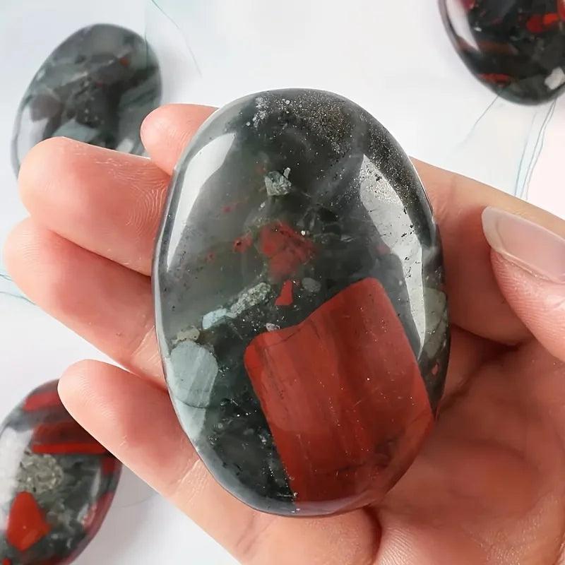 Polished bloodstone crystal palm stone with deep green and red jasper inclusions for stress relief.