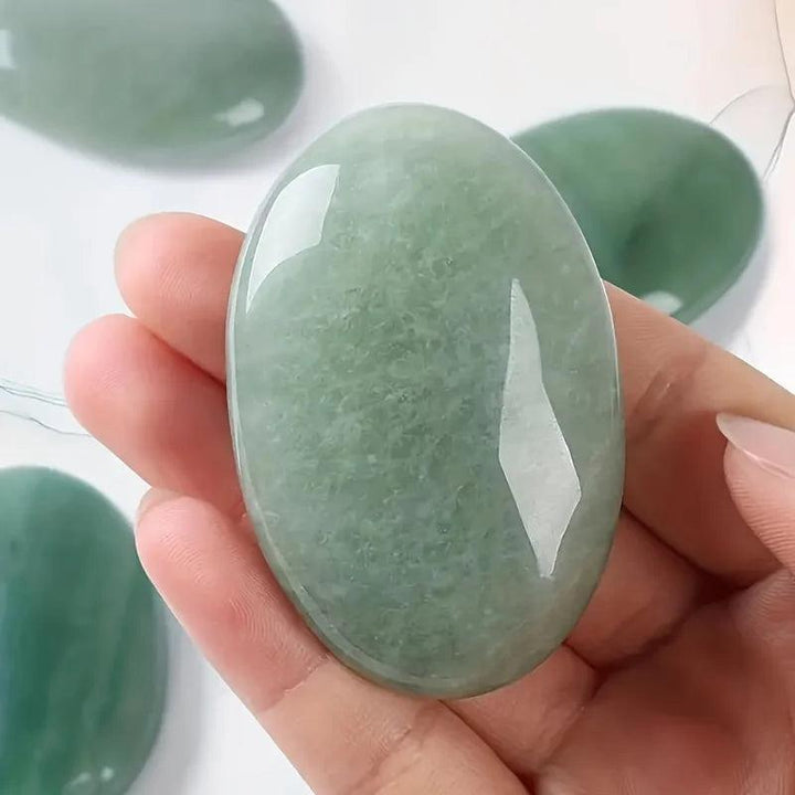 Green aventurine natural crystal palm stone, a polished oval pocket massage stone for stress relief.