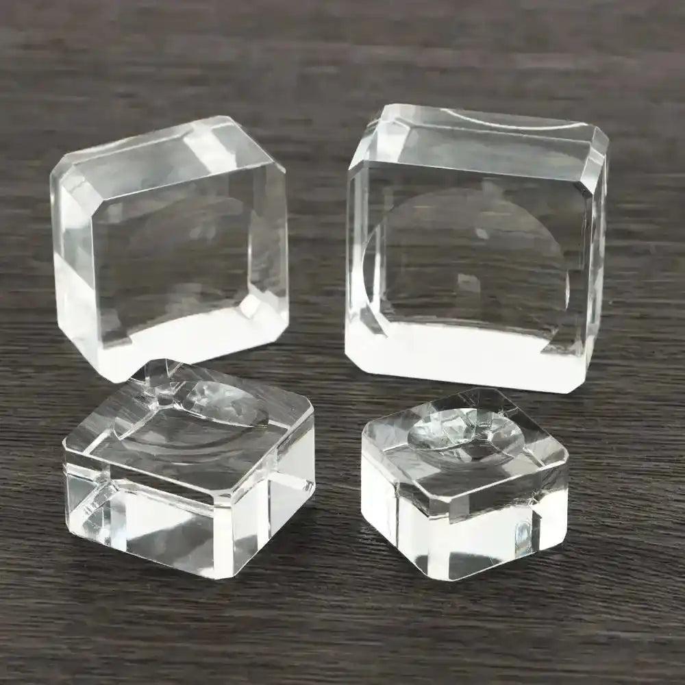 Assorted clear crystal sphere display stands in various faceted styles, perfect for elegant gemstone showcasing.