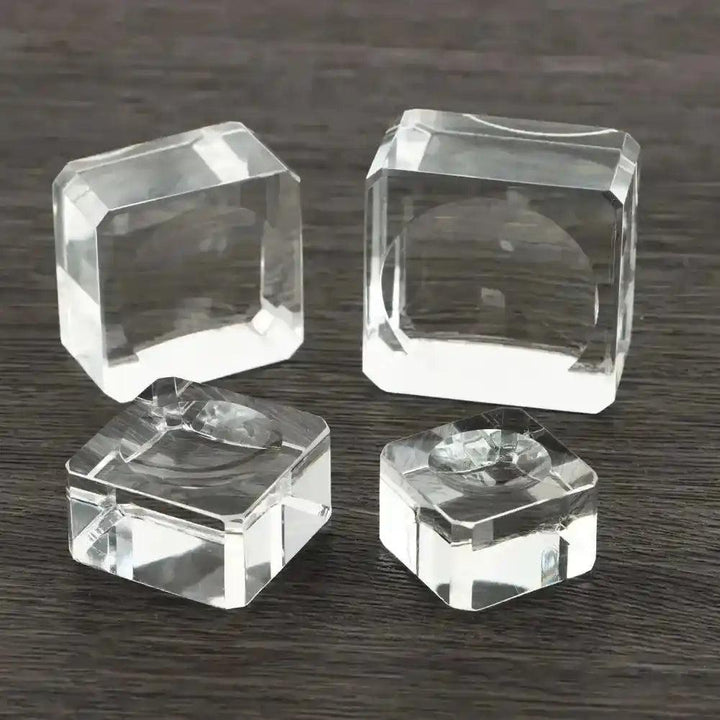 Assorted clear crystal sphere display stands in various faceted styles, perfect for elegant gemstone showcasing.