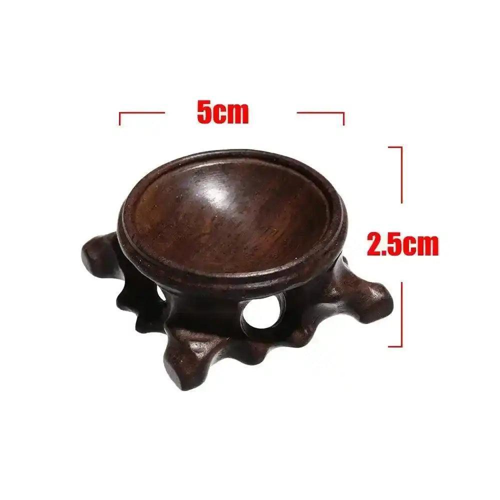 Dark brown wooden crystal sphere display stand, 5cm wide, 2.5cm tall, with four carved legs for elegant gemstone display.
