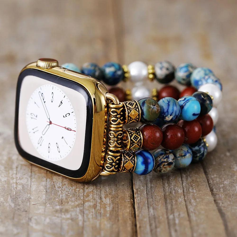 Gold Apple Watch with a multi-strand jasper crystal bead band, featuring earthy red, blue, and white tones.