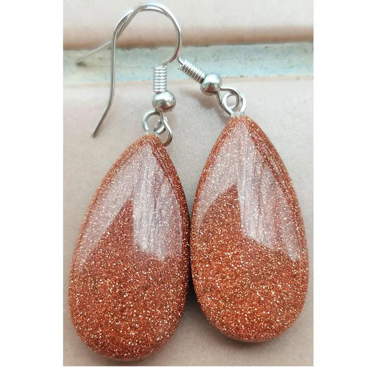 Sparkling goldstone teardrop drop earrings, set in copper wire, for grounding and confidence.