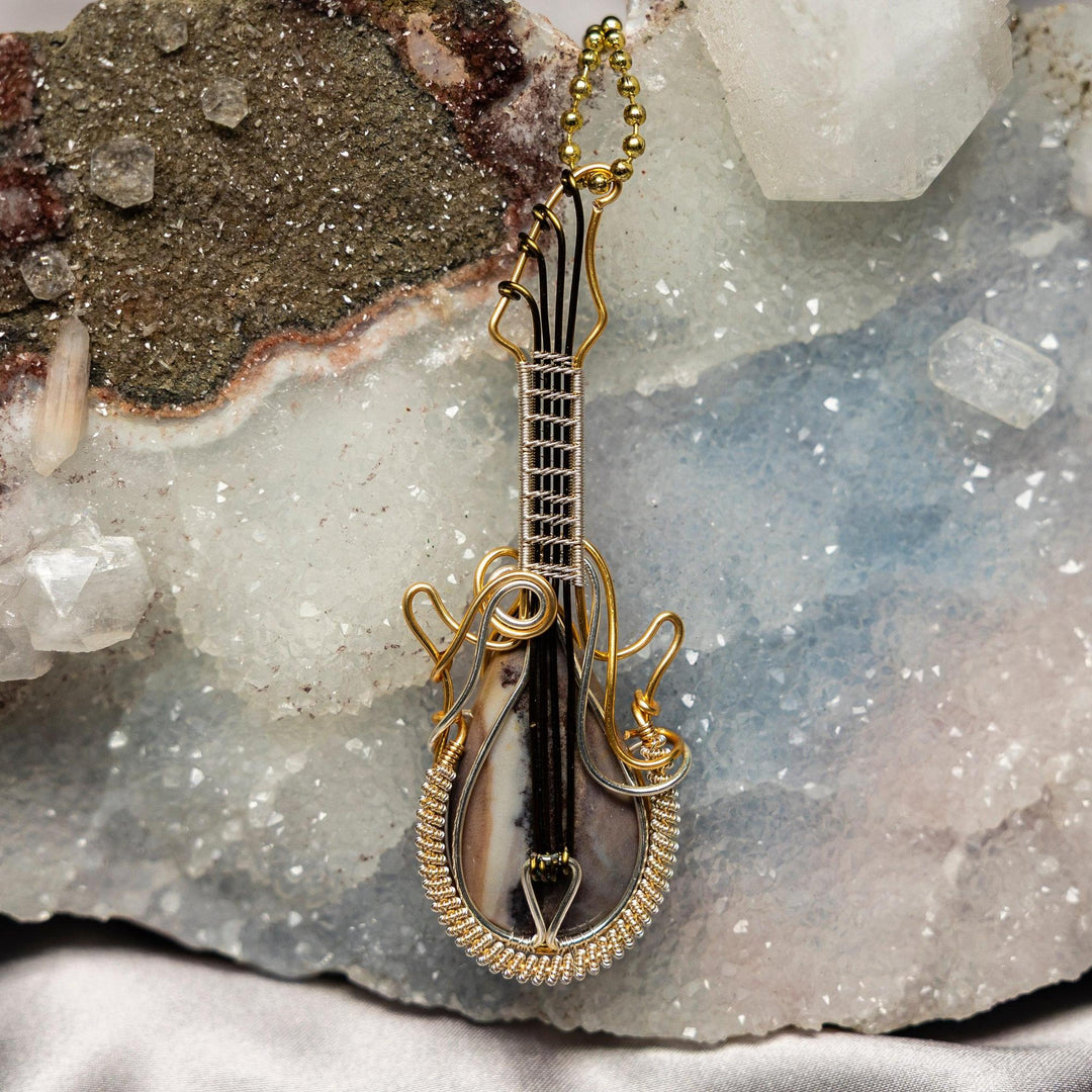 Captivating 3.25" Dendritic Agate guitar wire wrap pendant, handcrafted with copper, promoting stability and growth.