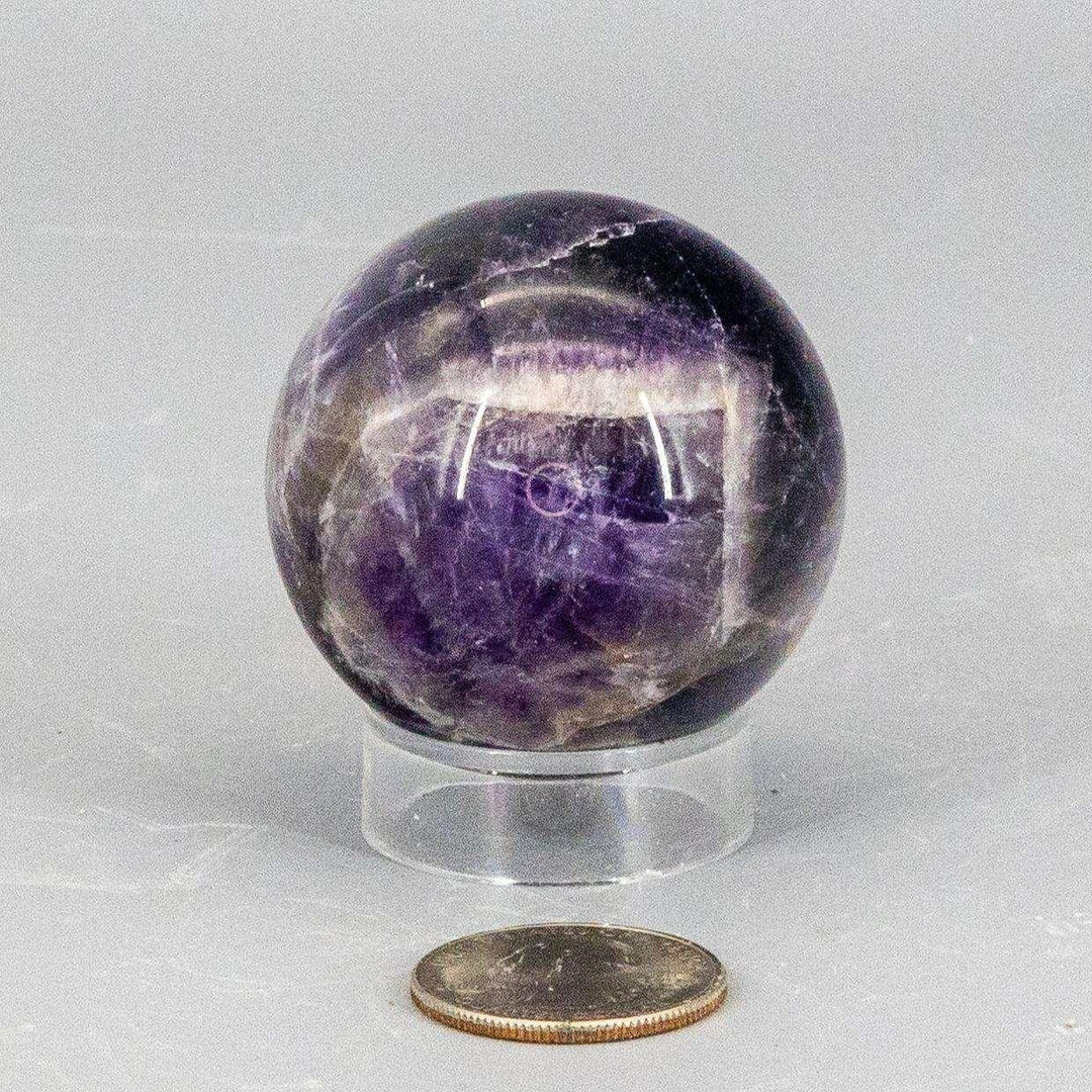 Dream Amethyst Sphere, 49mm, showcasing layered purple and white banding, polished to a smooth finish.