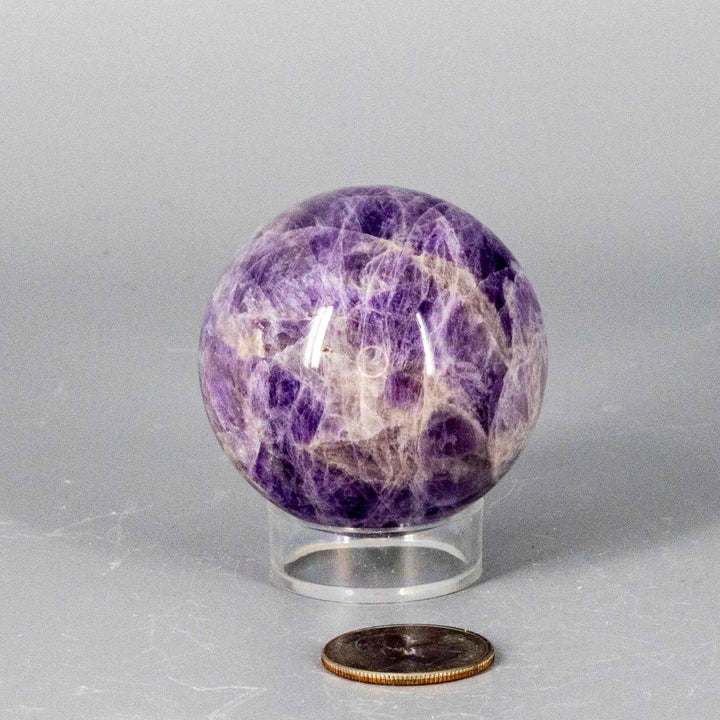 Dream Amethyst Sphere (51-57mm) with soft purple and white bands, radiating calming energy for sleep and meditation.