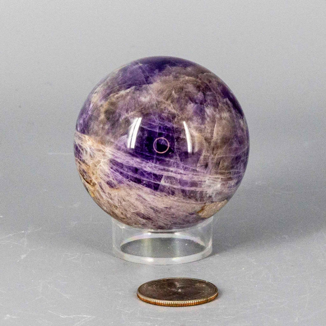 Dream Amethyst Sphere, 51-57mm, with flowing purple and white bands, radiating calming energy for restful sleep.