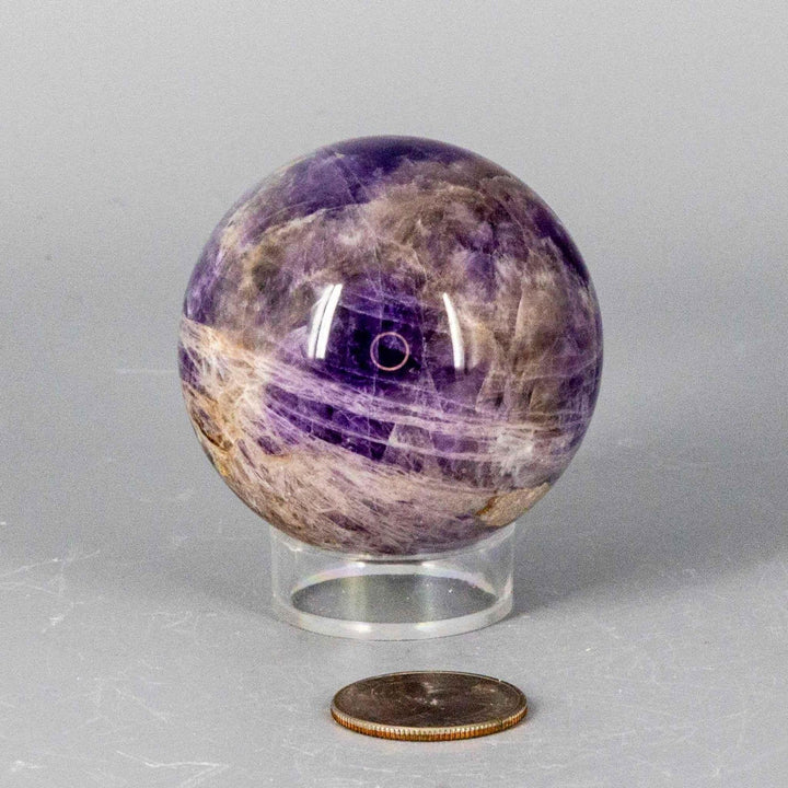 Dream Amethyst Sphere, 51-57mm, with flowing purple and white bands, radiating calming energy for restful sleep.