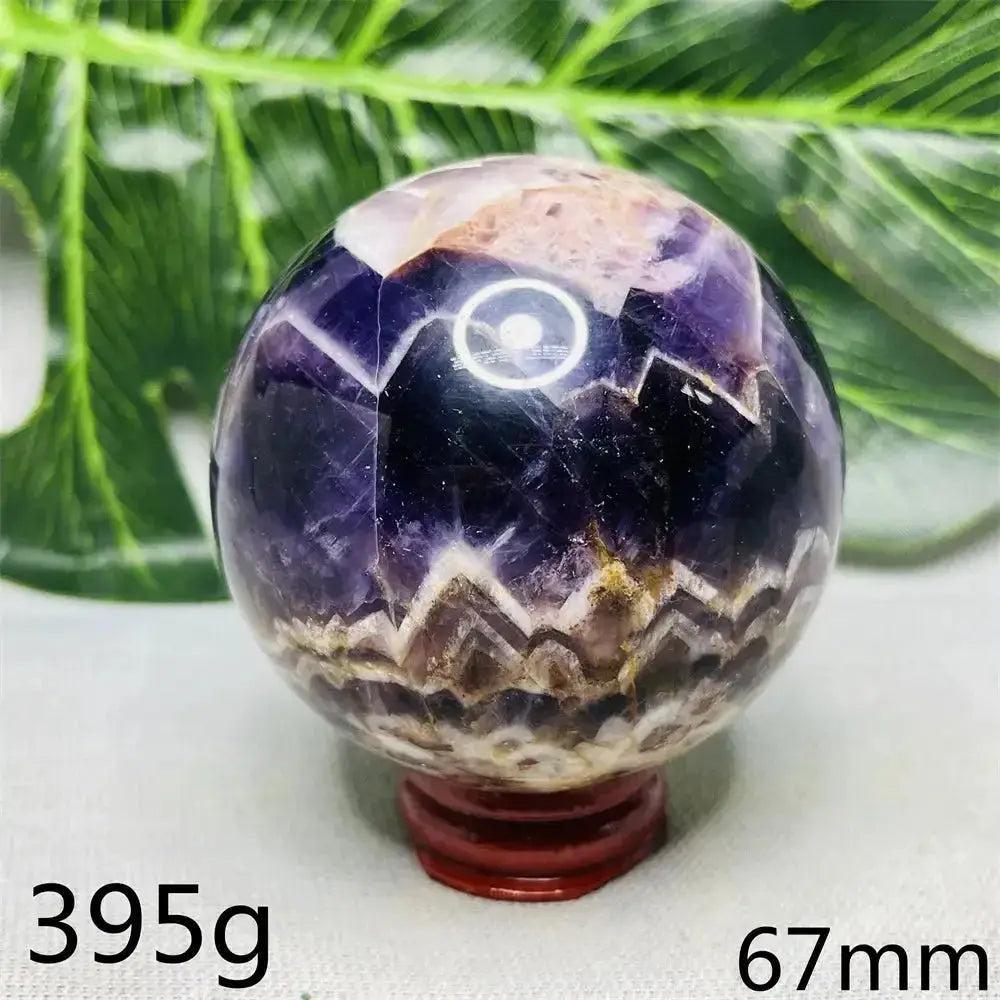 Dream Amethyst Geode Crystal Sphere: Polished deep violet sphere with sparkling inner clusters on a red stand.