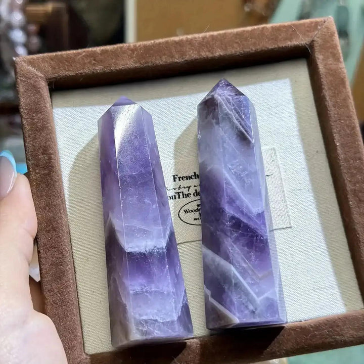 Two polished Dream Amethyst point towers featuring rich purple hues and natural white banding for meditation and calm.