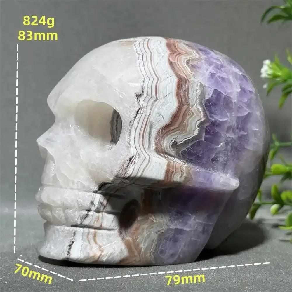 Hand-carved Dream Amethyst skull featuring layered purple amethyst and milky white quartz for intuition and calm.
