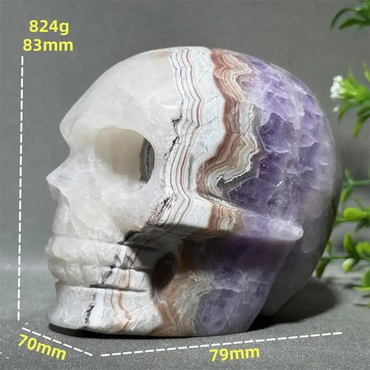 Hand-carved Dream Amethyst skull featuring layered purple amethyst and milky white quartz for intuition and calm.