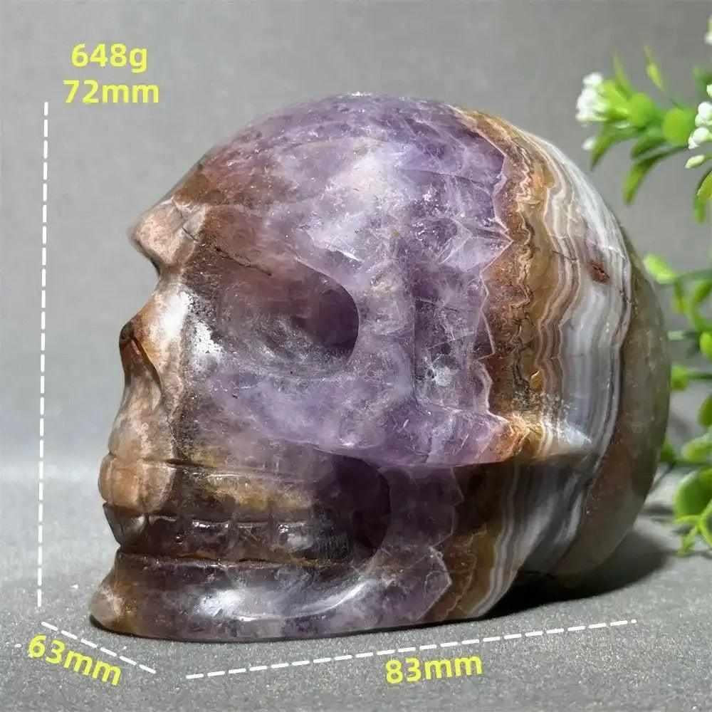 Hand-carved Dream Amethyst skull featuring layered purple and white quartz, perfect for meditation and intuition.
