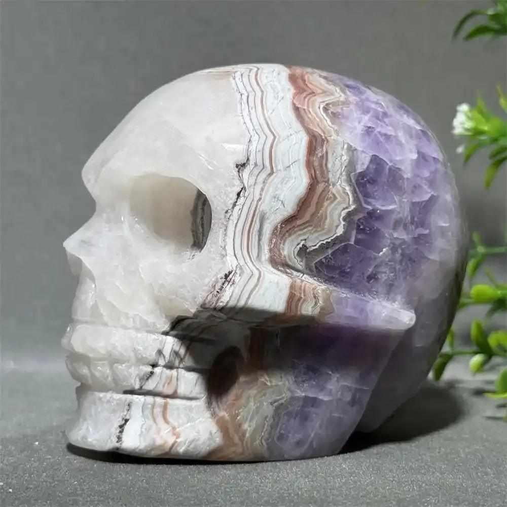 Hand-carved Dream Amethyst skull featuring layered purple amethyst and milky white quartz for intuition and calm.