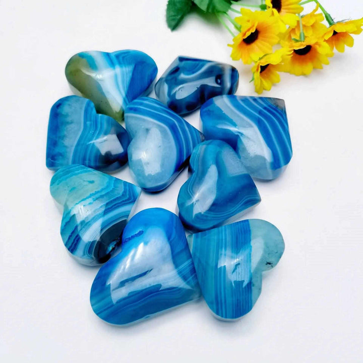 Polished dyed blue agate hearts with natural banding, perfect for Throat Chakra healing and calming, peaceful displays.