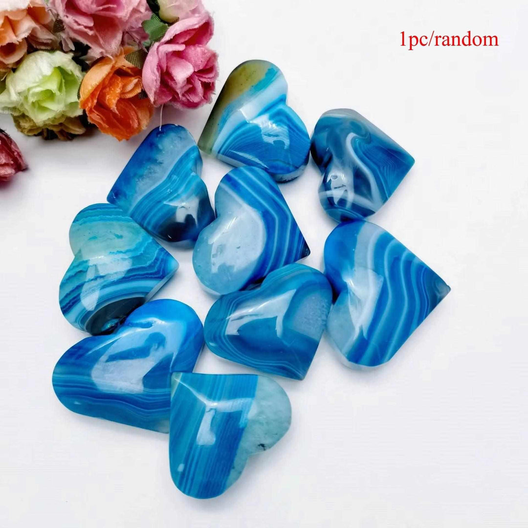 Polished blue agate heart palm stone with natural banding, perfect for Throat Chakra healing and calming meditation.