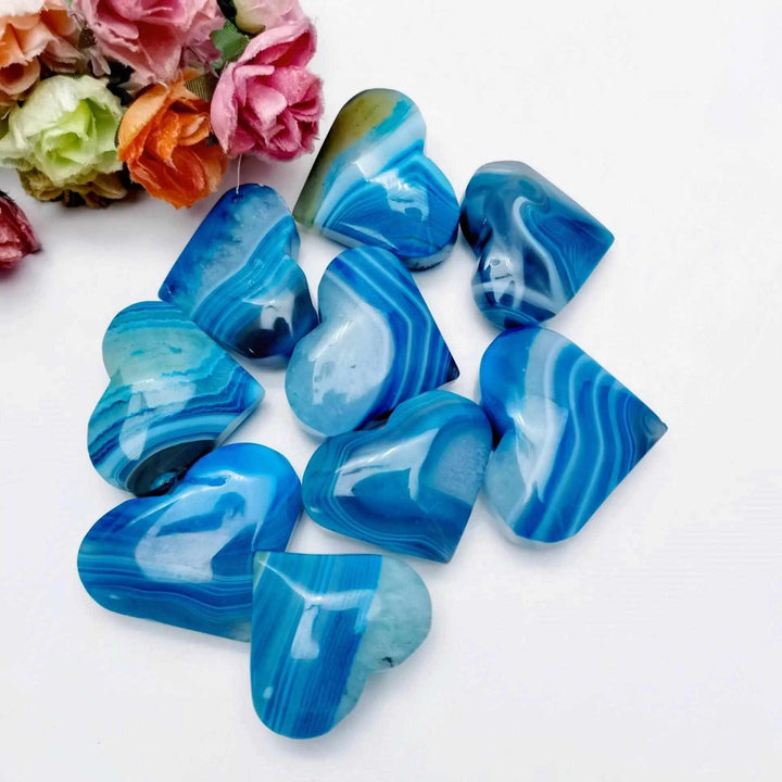 Polished blue agate hearts with natural banding, perfect for Throat Chakra healing and calming, meditative displays.