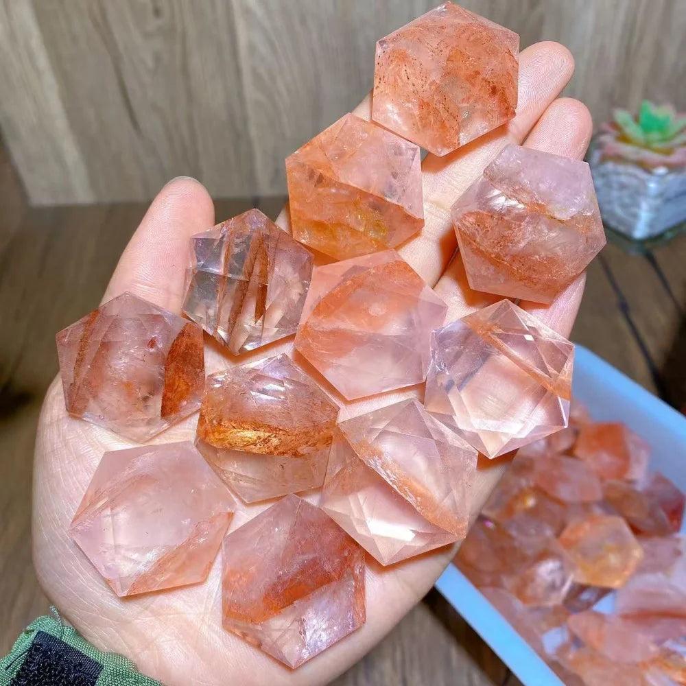 Hand holding multiple Fire Quartz Crystal Carved Hexagram Star DIY Pendants, showcasing their vibrant red and clear hues.