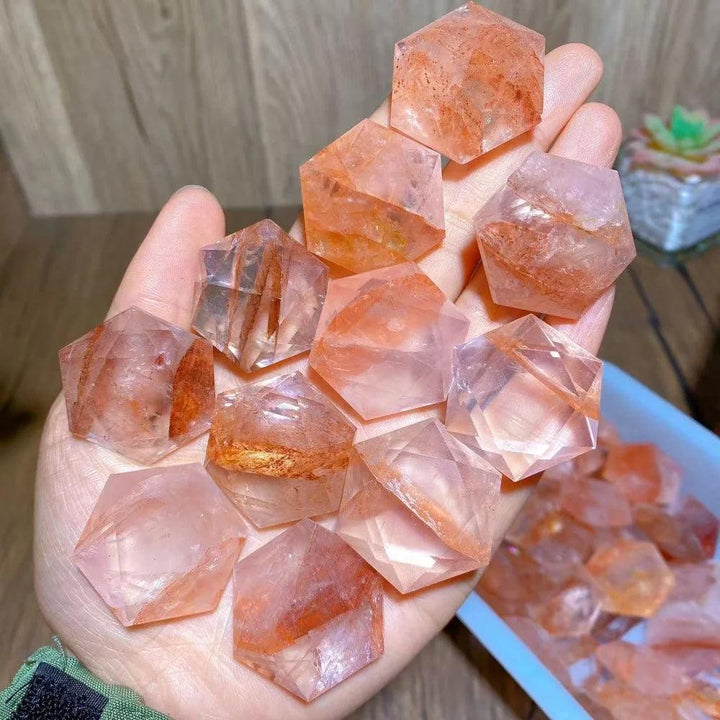 Hand holding multiple Fire Quartz Crystal Carved Hexagram Star DIY Pendants, showcasing their vibrant red and clear hues.