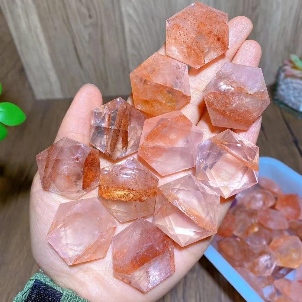 Hand holding several polished Fire Quartz Hexagram Star pendants, showcasing their activating, grounding energy.