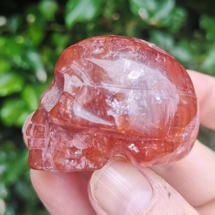 Polished natural Fire Quartz skull ornament with deep red hues, perfect for healing energy and unique holiday decor.