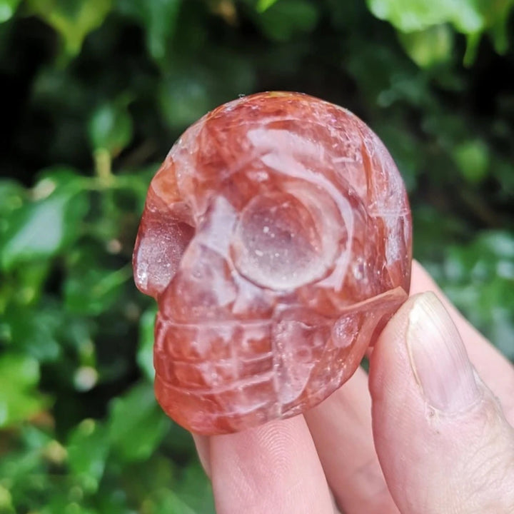 Hand-carved Natural Fire Quartz skull ornament with deep red hues, perfect for healing decor and unique holiday gifting.