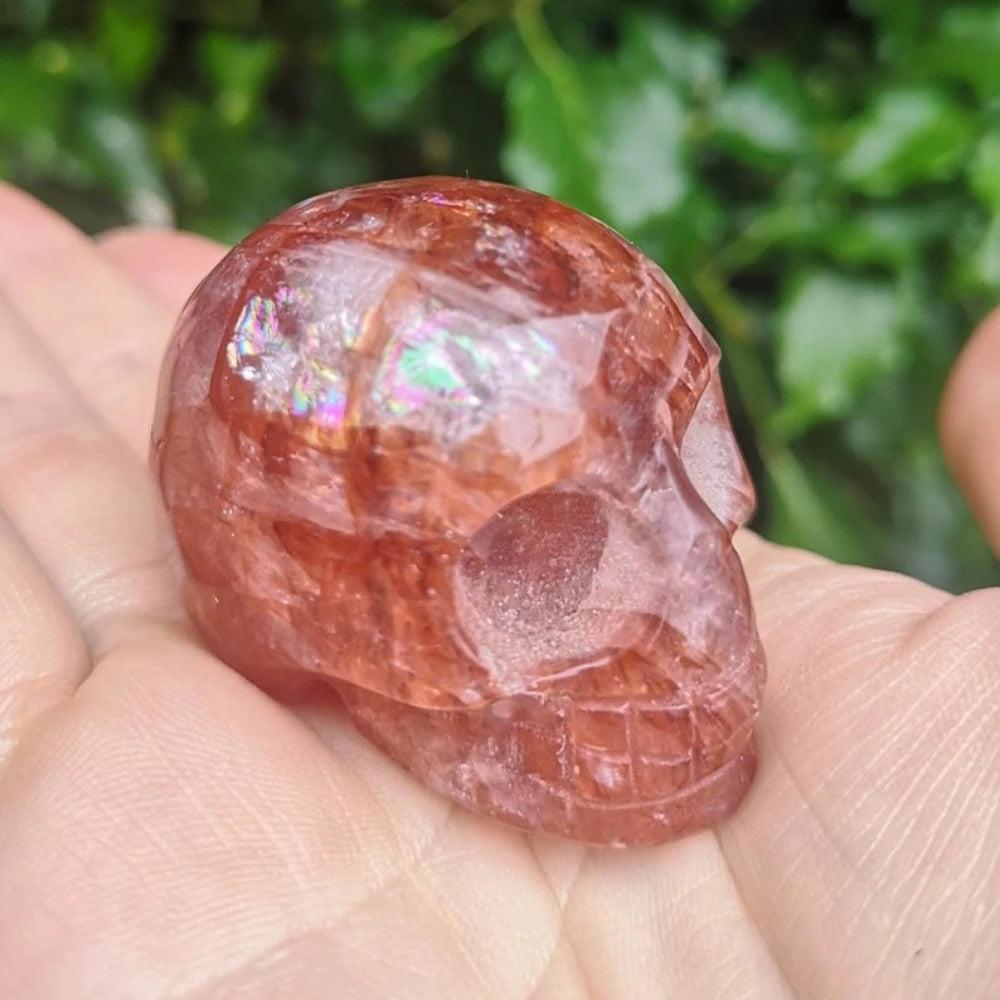 Hand-carved Natural Fire Quartz skull ornament with vibrant red hues and shimmering iridescent inclusions for healing.