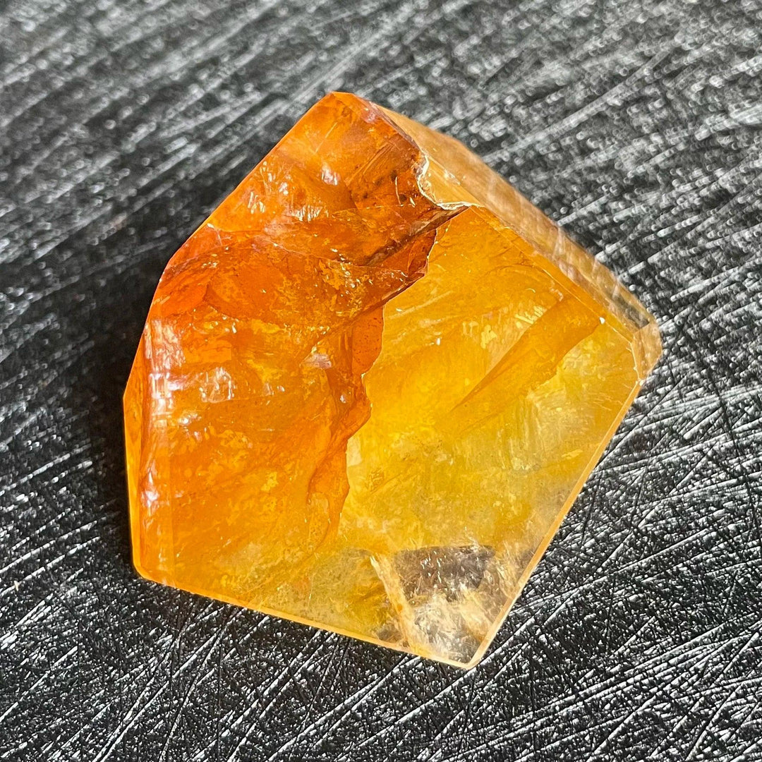 Polished Fire Quartz crystal freeform, glowing with warm orange, amber, and rust tones, showcasing natural inclusions.
