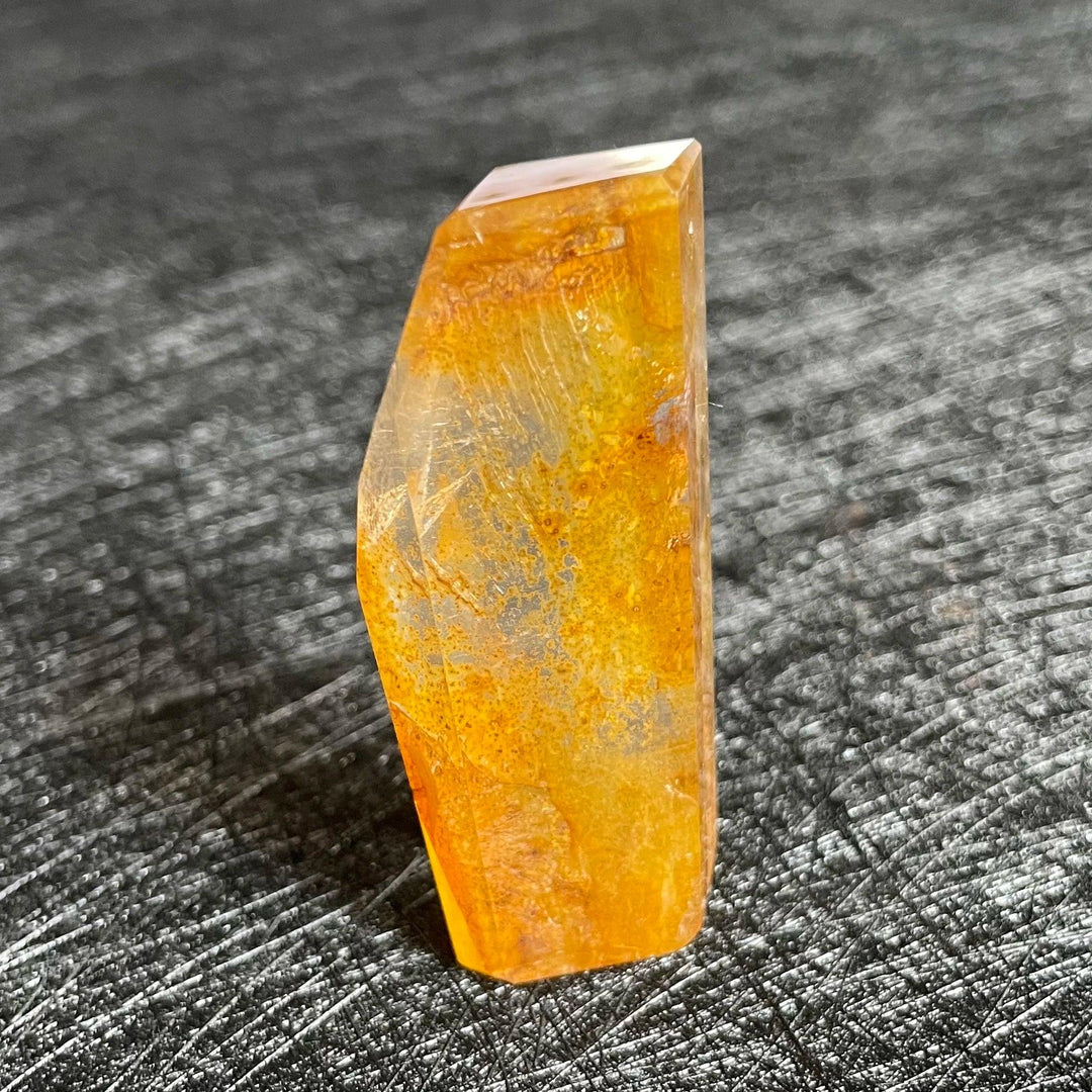 Polished Fire Quartz crystal freeform, showcasing warm orange and rust iron oxide inclusions within clear quartz.