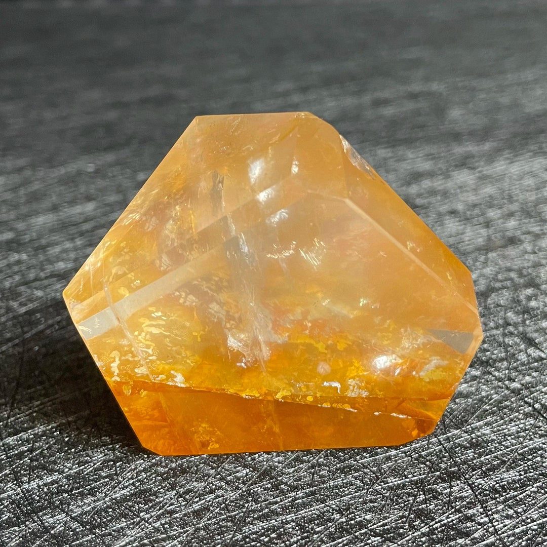 Polished Fire Quartz freeform crystal, glowing with warm orange and amber iron oxide inclusions, promoting energy and balance.